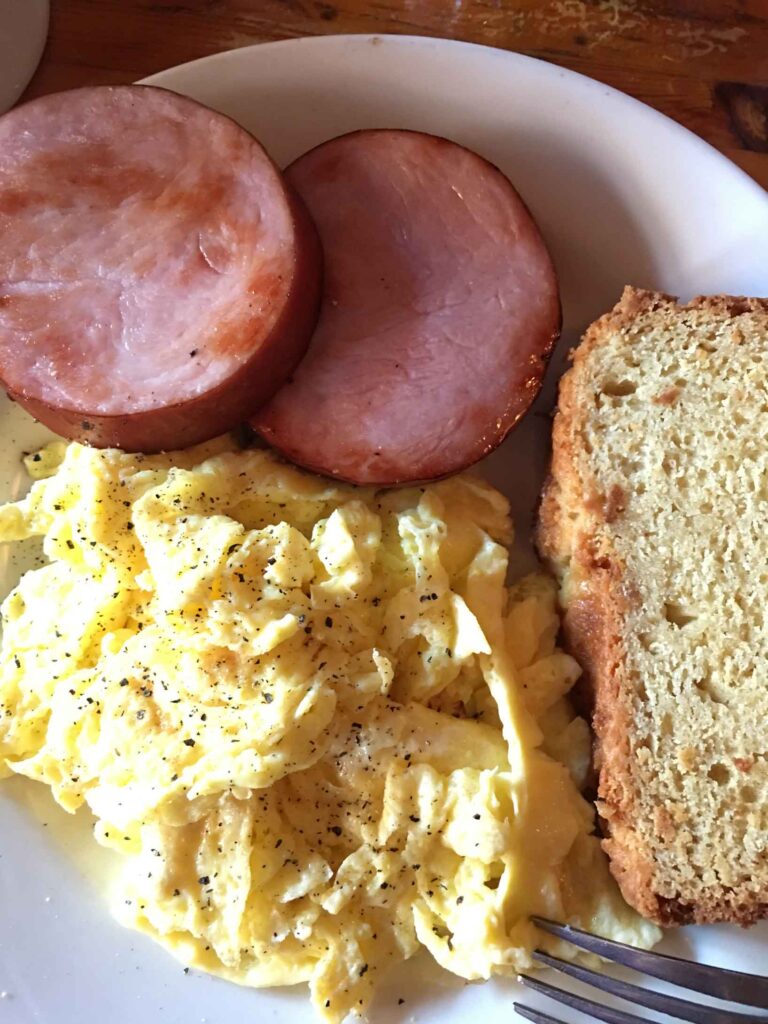 plate of breakfast food eggs ham and bread