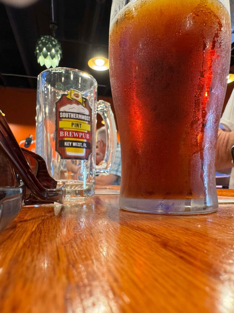 Beer on a bar top with a cup saying southernmost brewpup