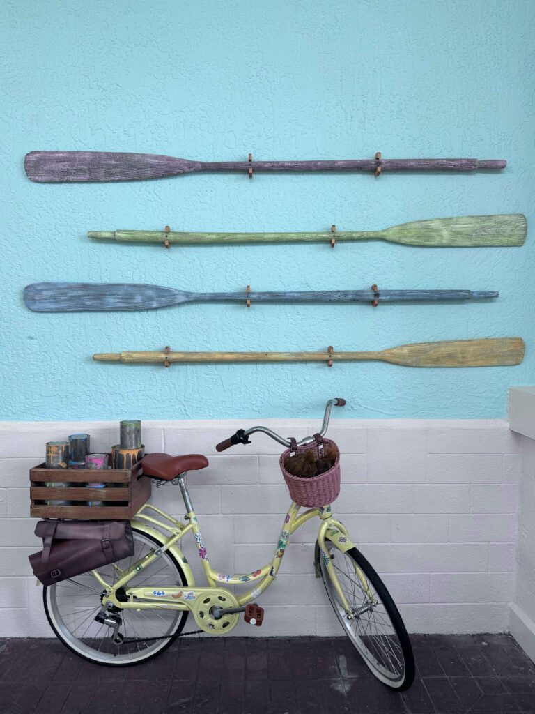 bike leaning against a wall with boat oars